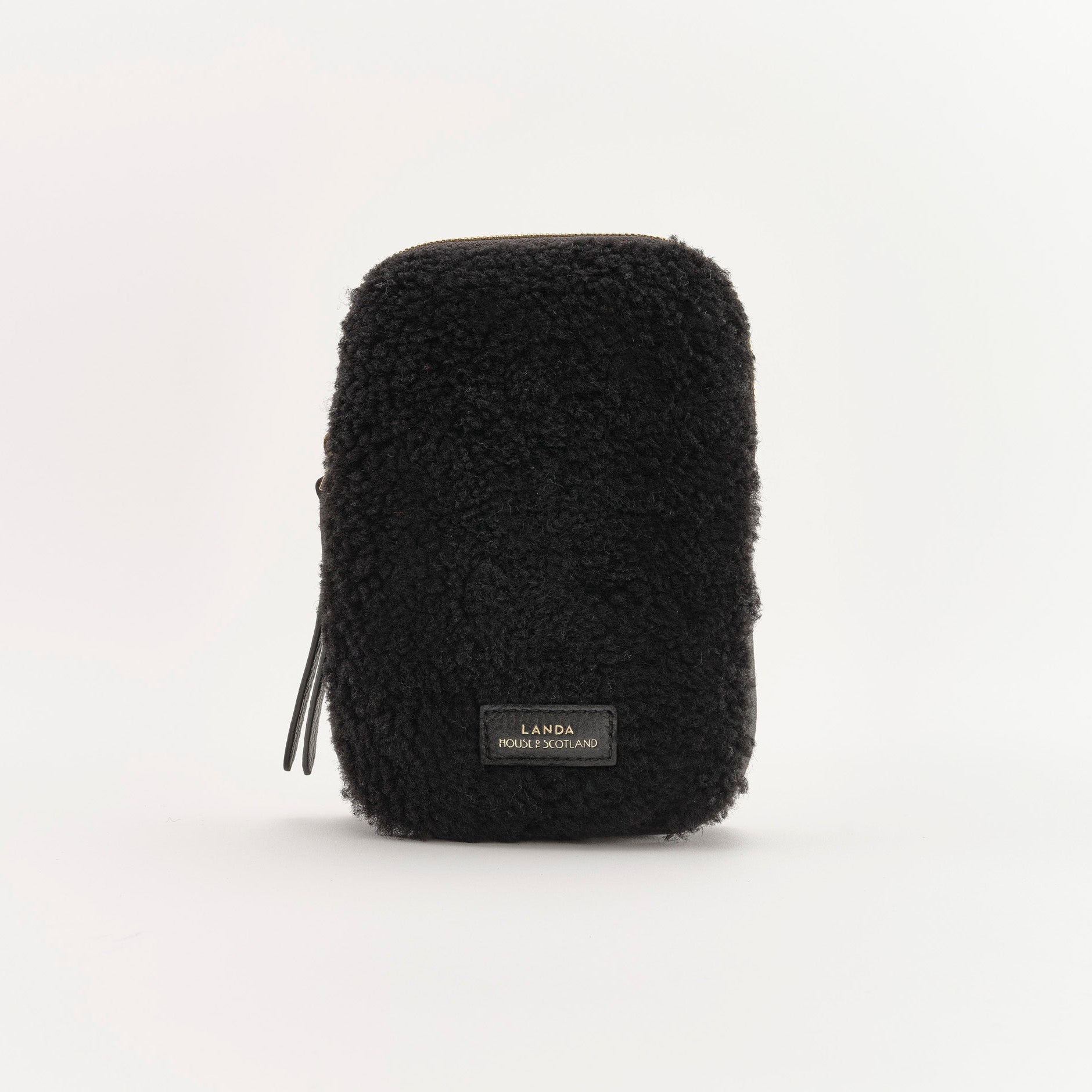 Black textured pouch with a brand label on a white background