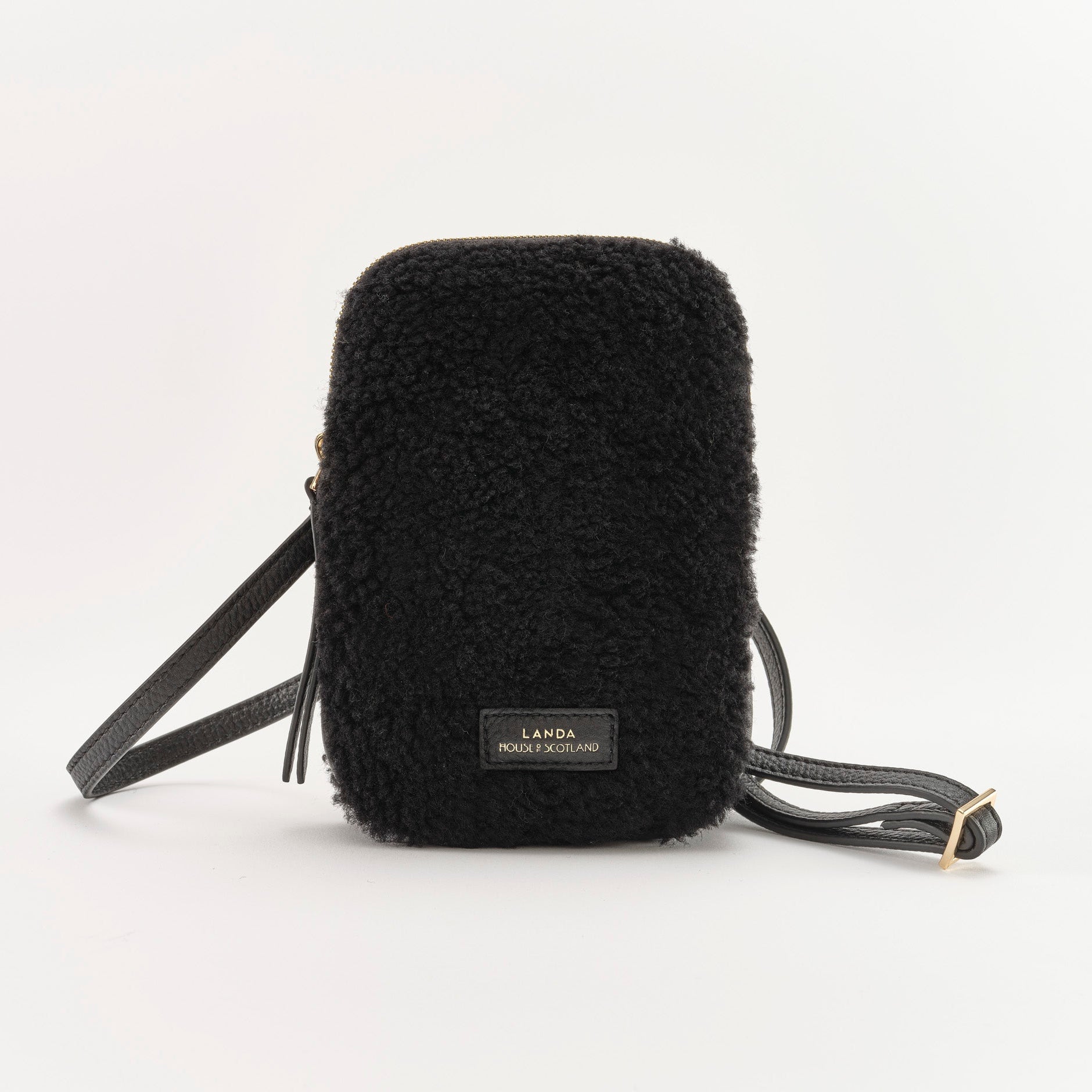 Black fluffy crossbody bag with visible brand label on a white background