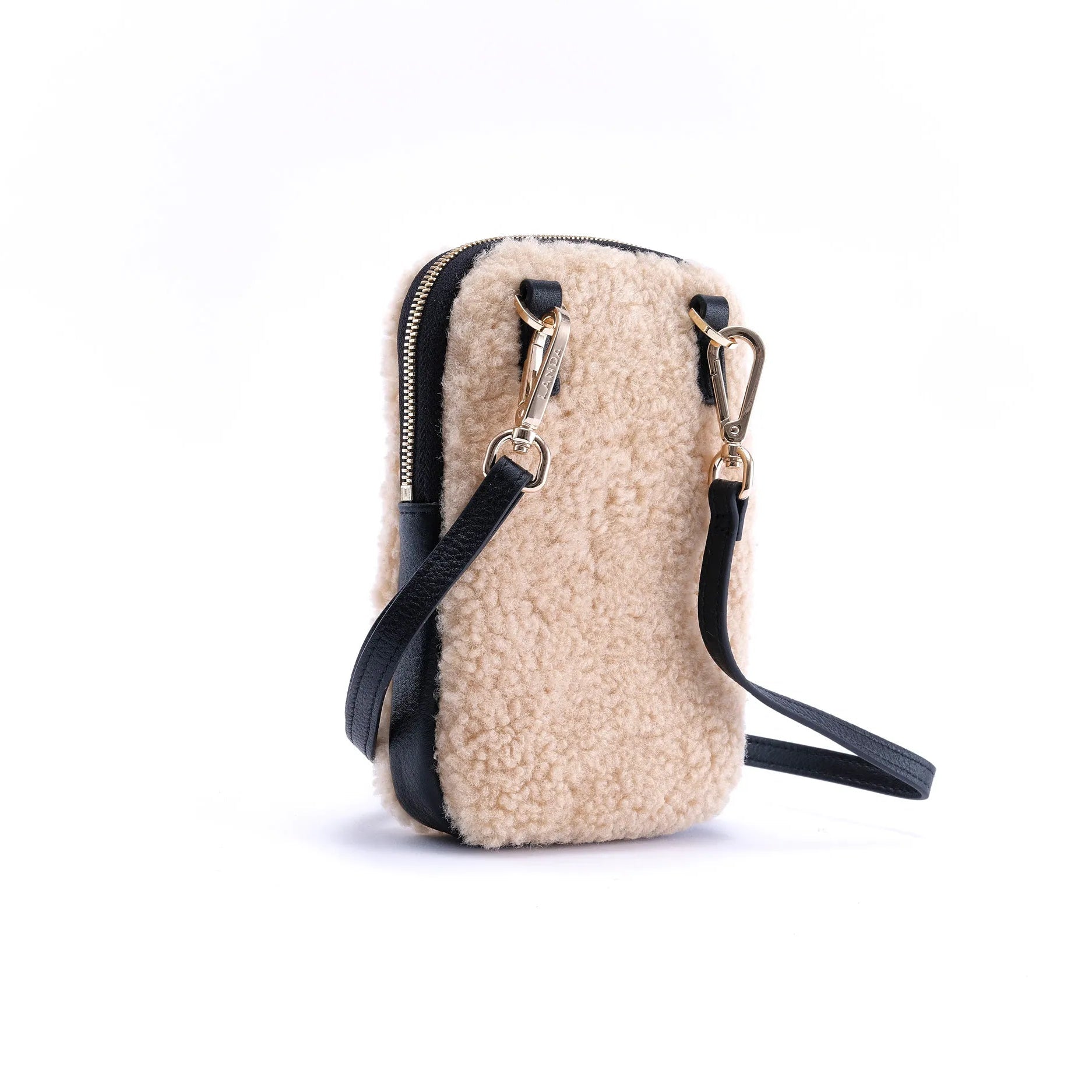 Beige real shearling phone bag with black leather strap on a white background