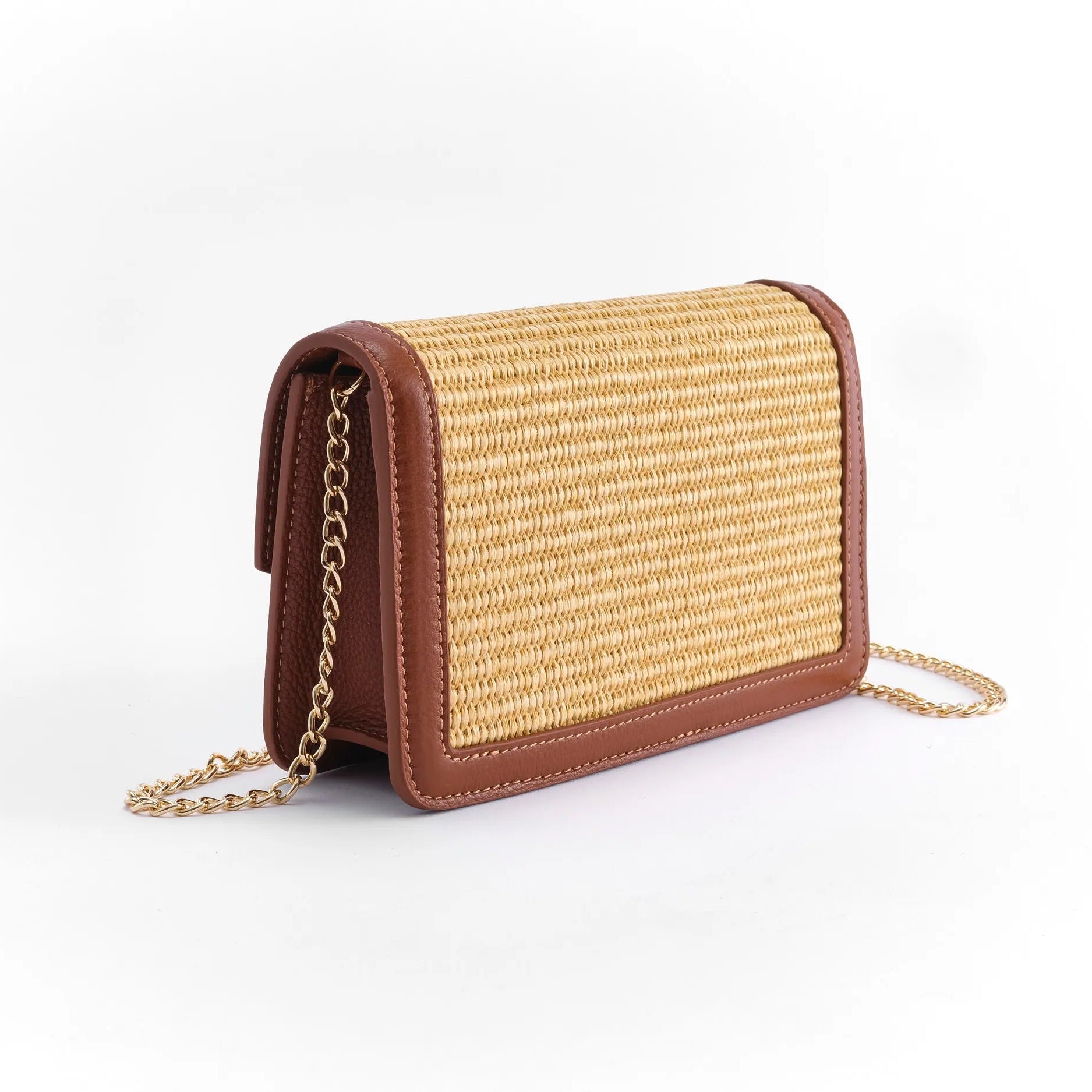 Raffia handbag with tan leather accents and a gold chain strap on a white background